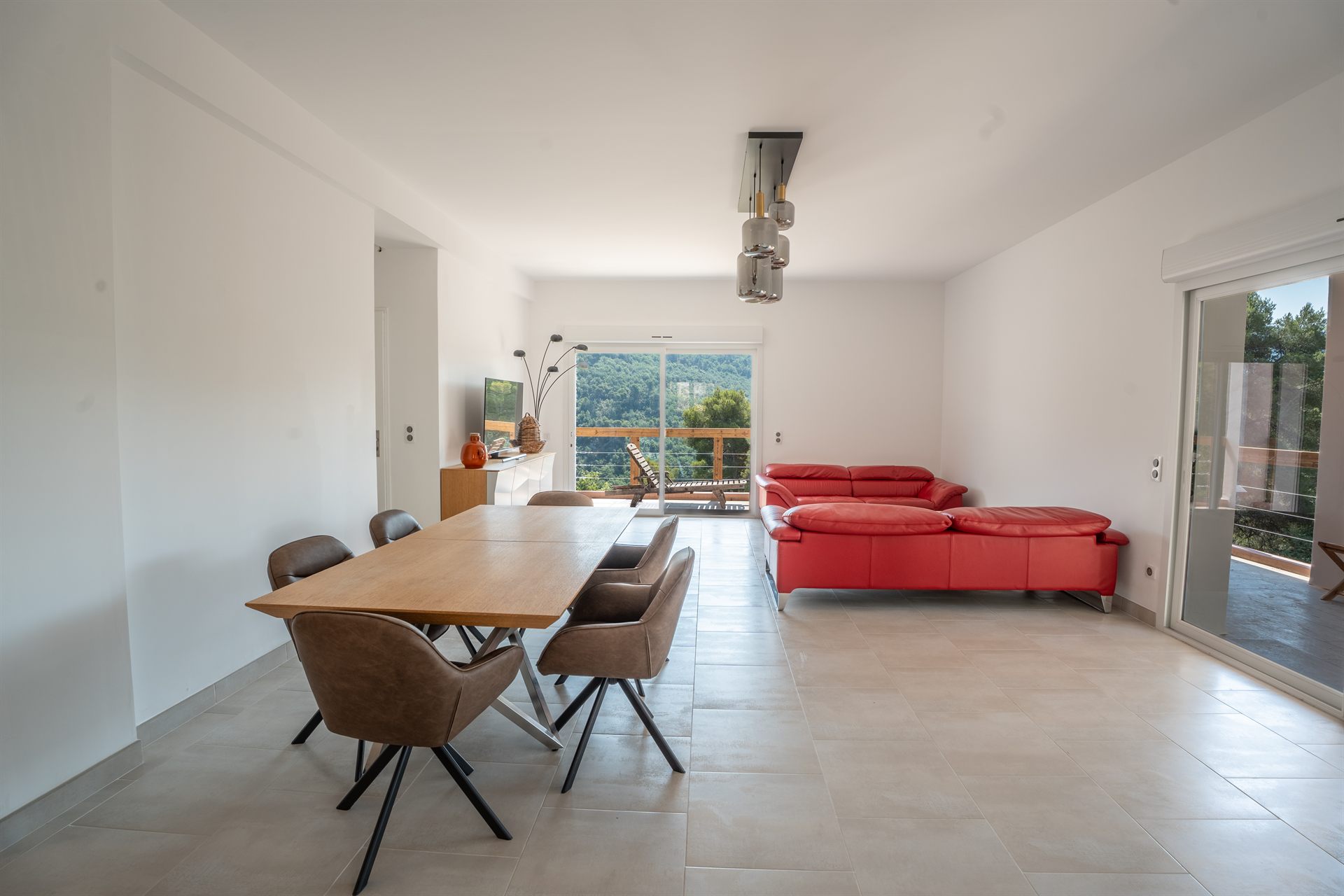 Le séjour de la Villa Gorgetta, cuisine ouverte et baies vitrées sur le balcon