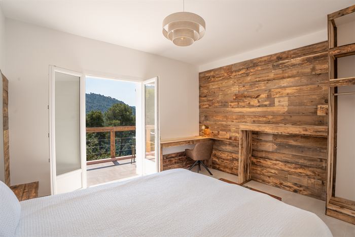 Chambre avec porte-fenêtre ouverte sur la vue