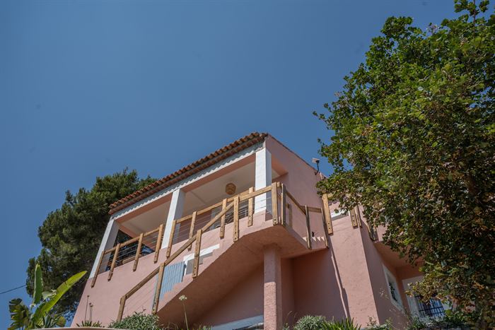 La villa vue depuis le terrain, entourée de verdure